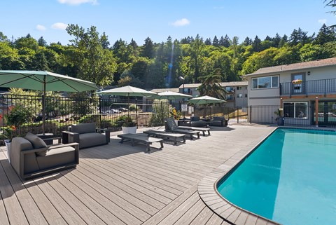A wooden deck with a pool and patio furniture.
