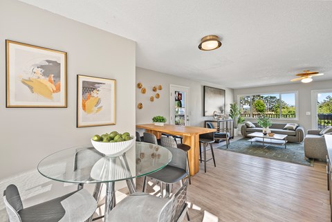A modern dining room with a glass table and chairs.