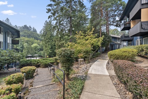 A pathway with a metal railing on the left side and a building on the right side.
