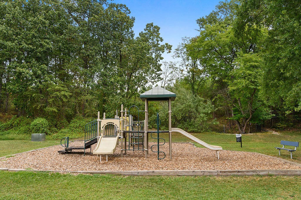 a playground with a swing set and slides in a park at ReNew Odenton, Odenton