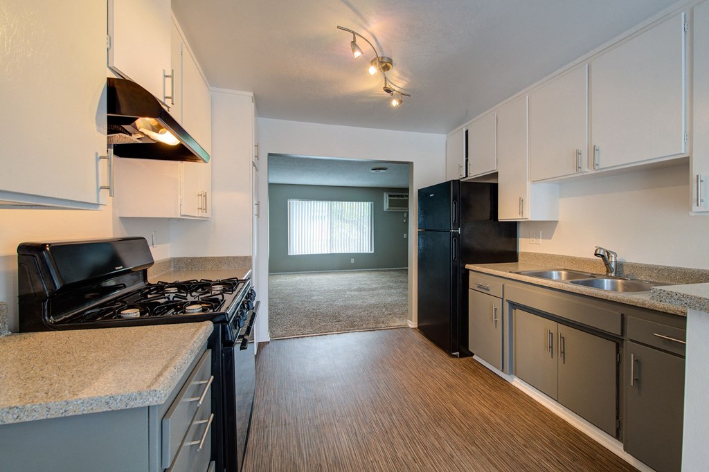 a kitchen with white cabinets and black appliances
