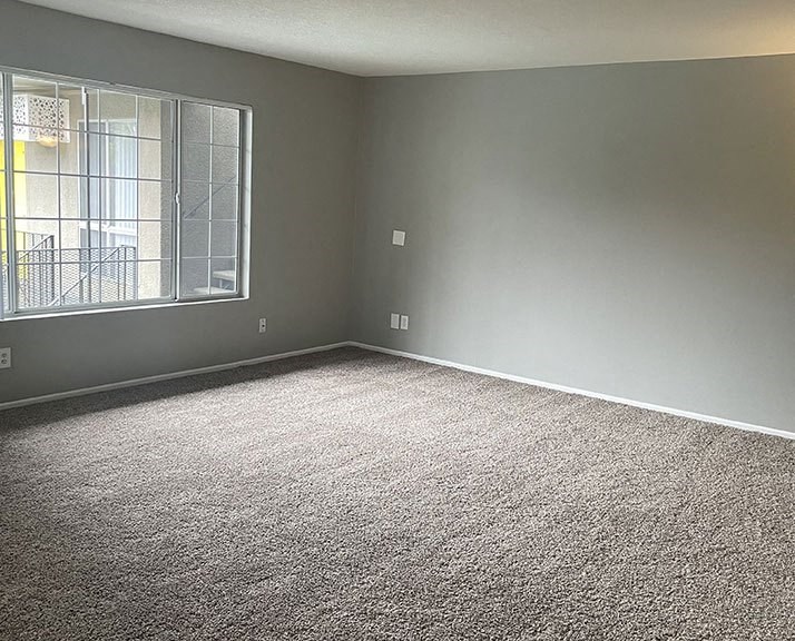 an empty room with a large window  at Dwell Apartment Homes, California, 92507