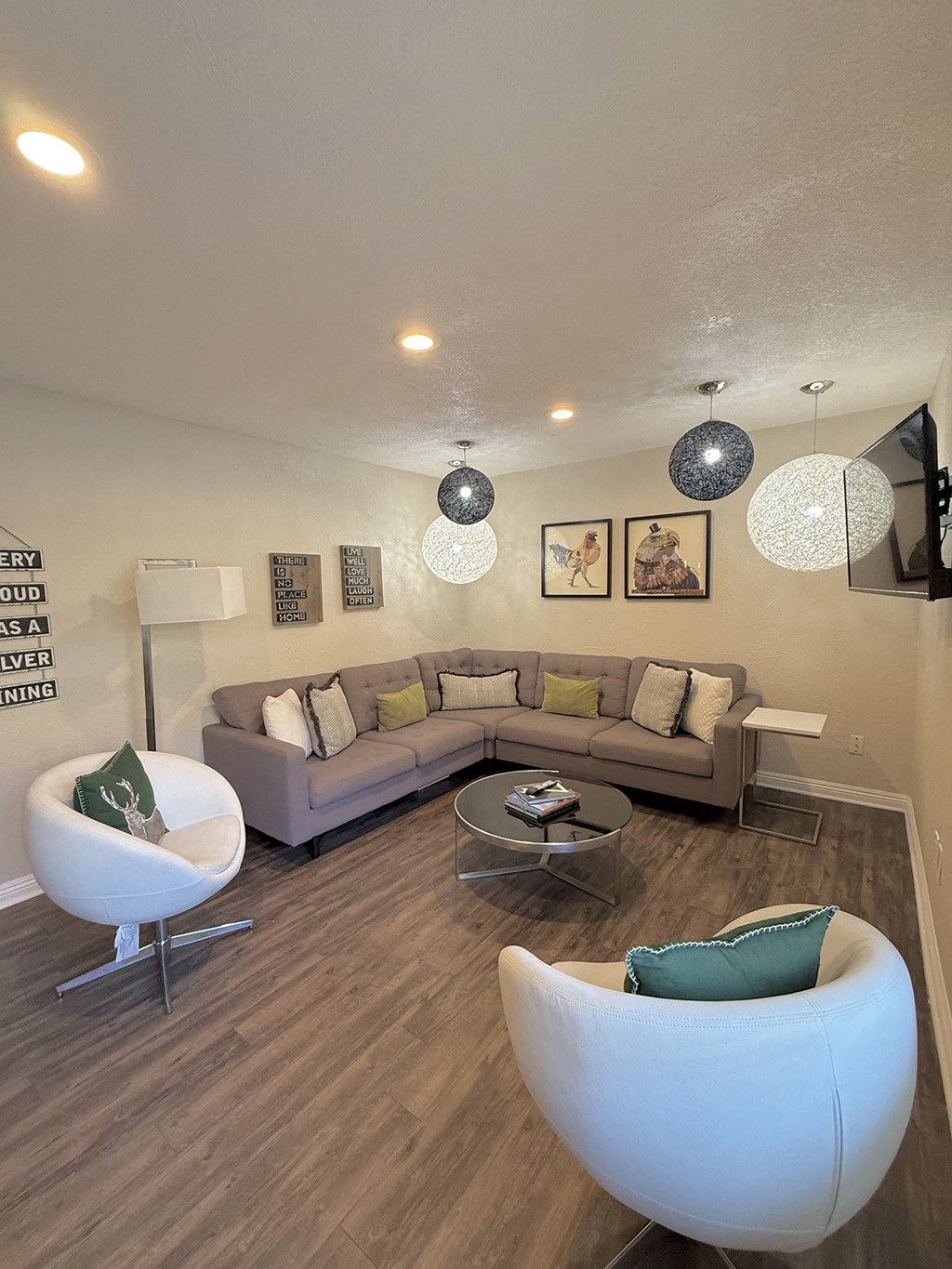 A living room with a grey couch, a white chair and a coffee table.