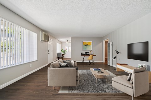A living room with a couch, chair, and television.