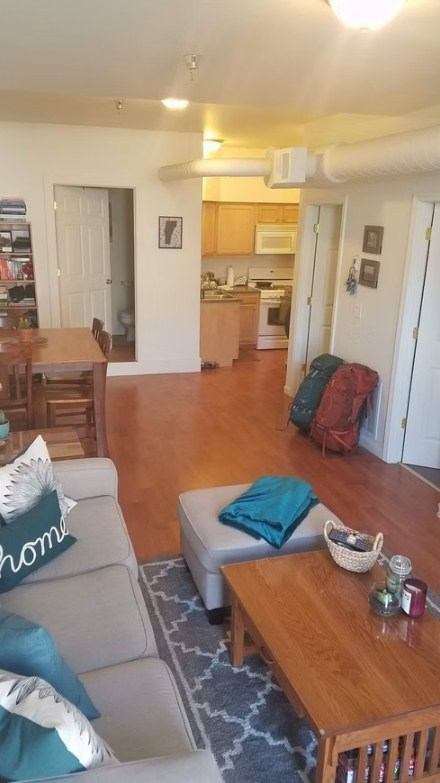 A living room with a grey couch and a wooden table.
