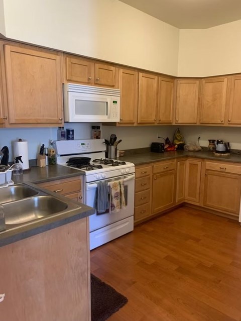 kitchen interior with wooden cabinets and a white stove top oven. kitchen interior with wooden cabinets and a white stove top oven at Eagle North Apartments, Burlington, 05408