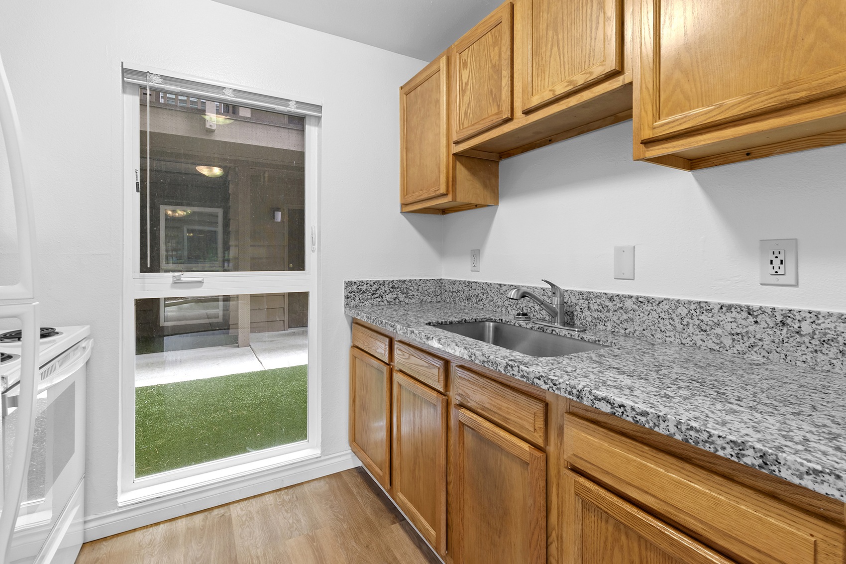 A kitchen with wooden cabinets and granite countertops.