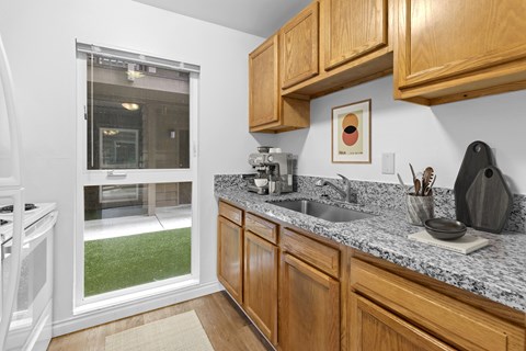 A kitchen with wooden cabinets and a granite countertop.
