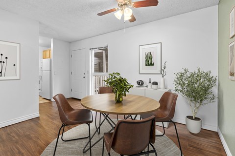 A dining room with a round table and chairs.
