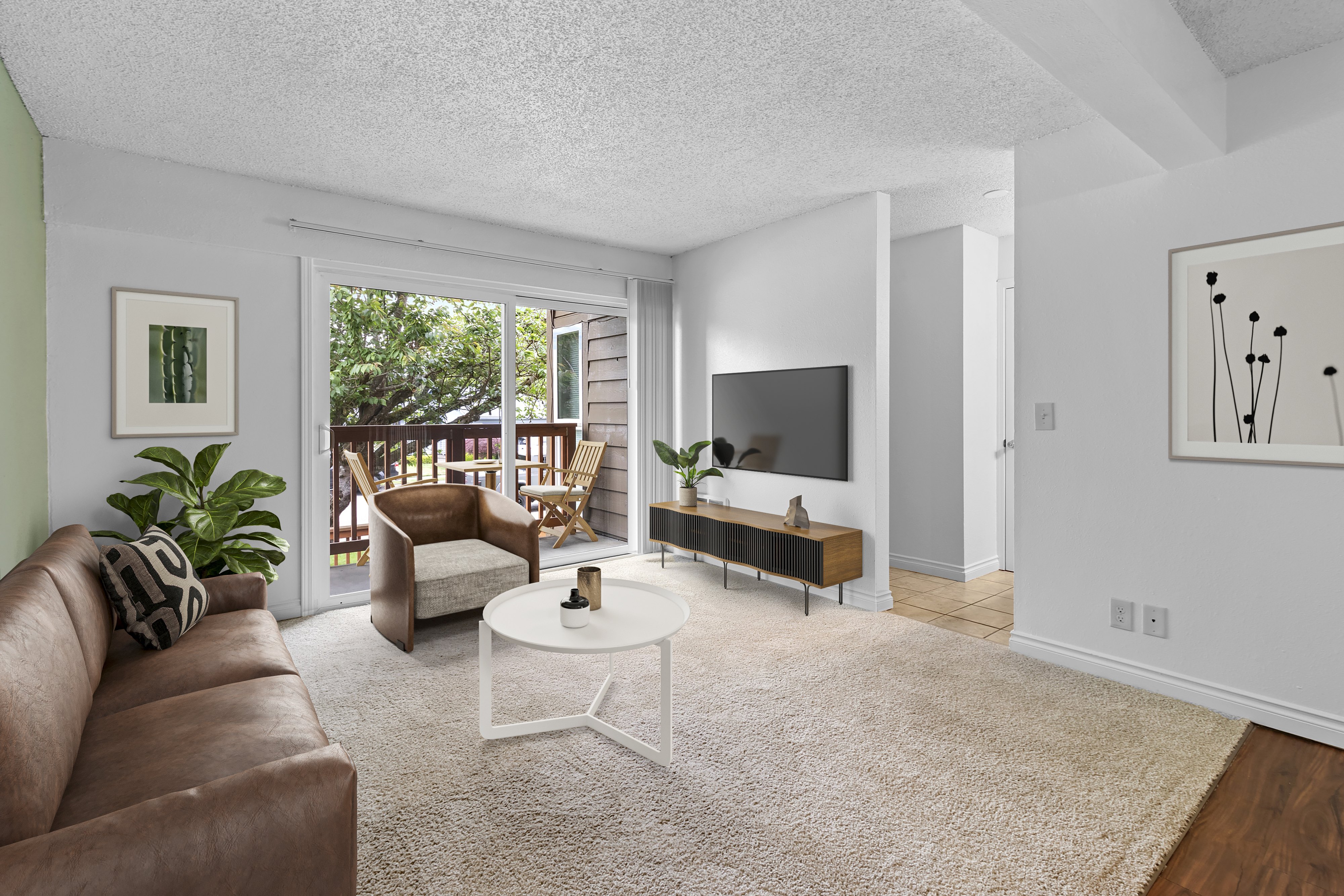 A living room with a brown couch and a white coffee table.