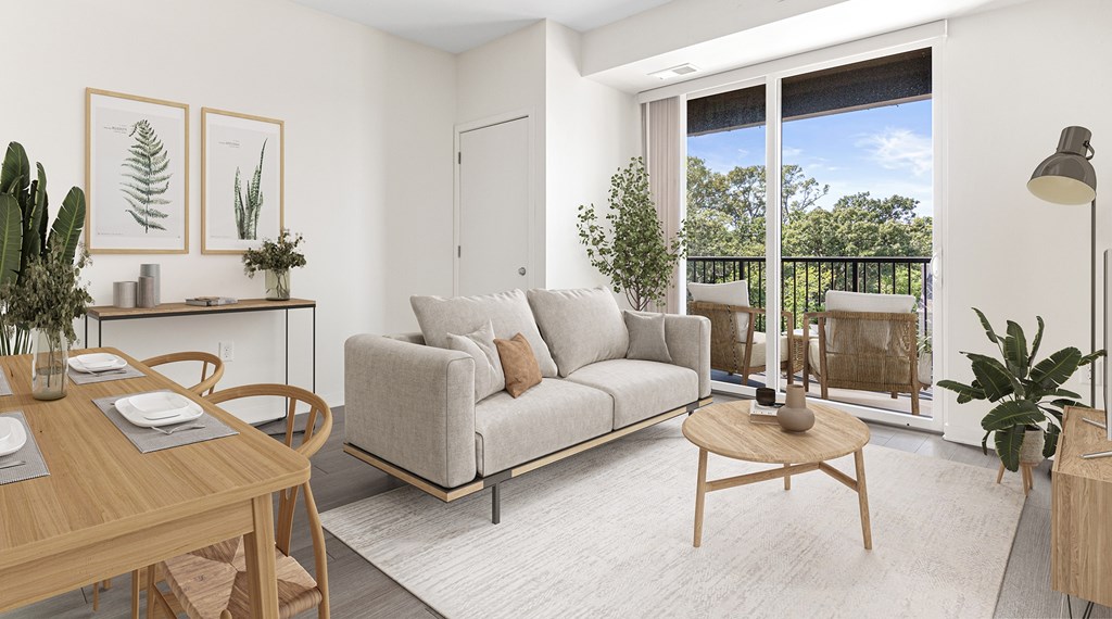 A living room with a grey couch, a wooden table, and a sliding glass door.