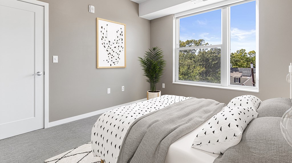A bedroom with a large bed and a picture on the wall.