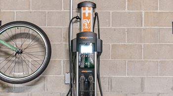 A bicycle is parked next to a charging station.