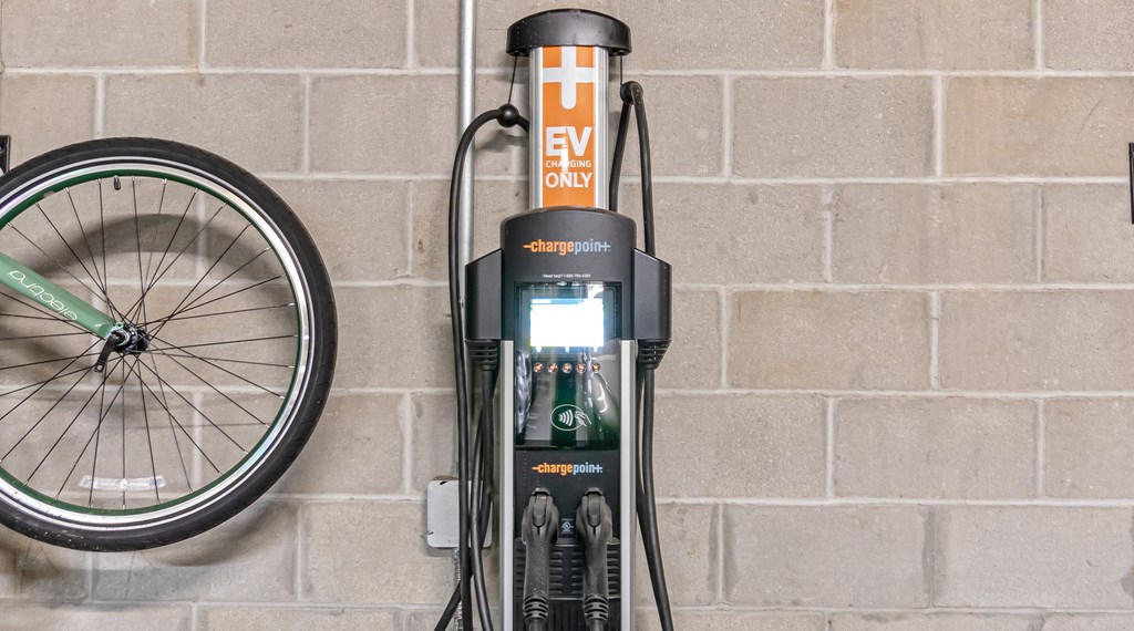 A bicycle is parked next to a charging station.