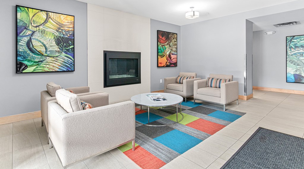 A sitting room with a white couch, a coffee table, and a painting on the wall.