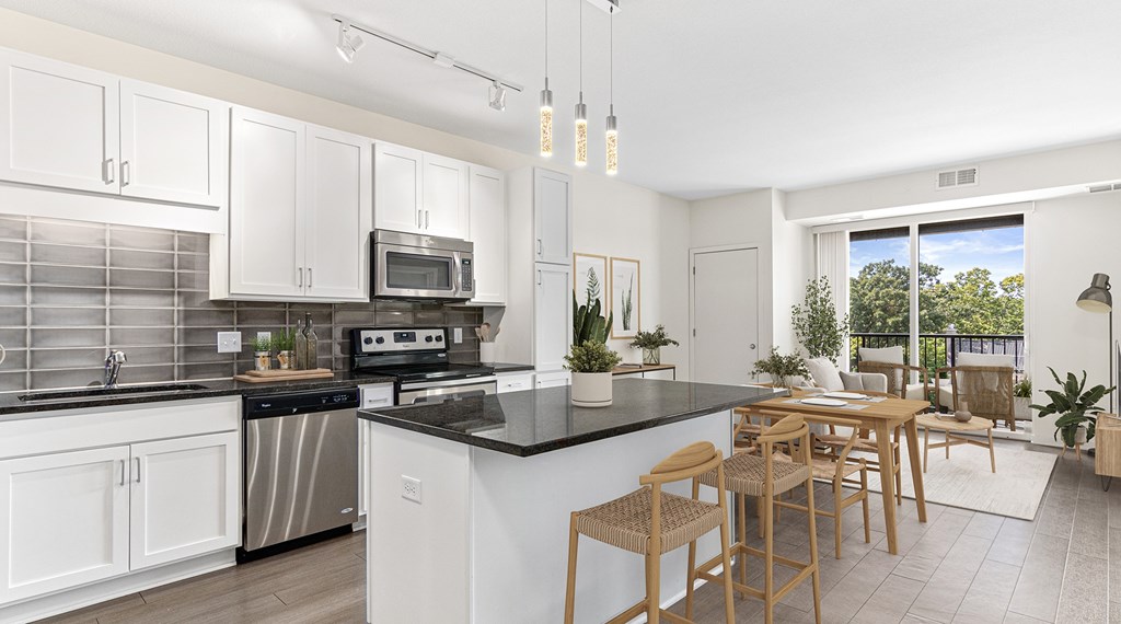 A modern kitchen with white cabinets and a black countertop.