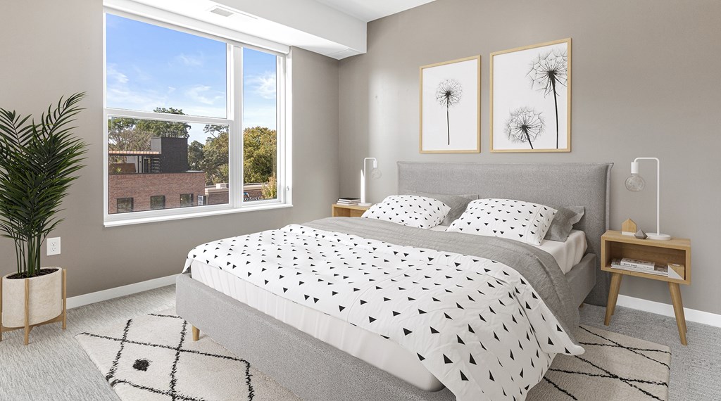 A bedroom with a large bed and a potted plant.
