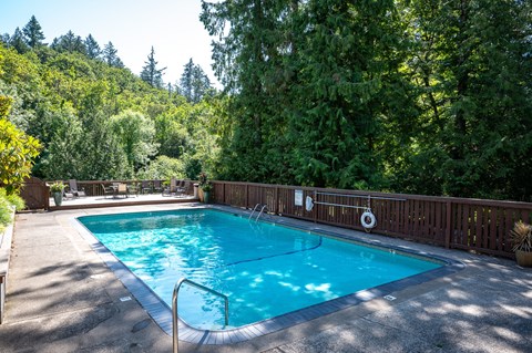 Swimming Pool With Relaxing Sundecks by a wooden fence and trees at Timberlee, Portland, OR, 97221