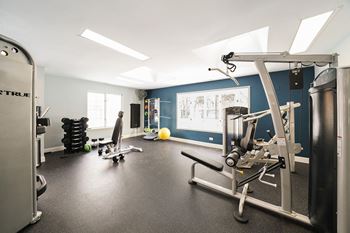 a gym with exercise equipment and a whiteboard on the wall
