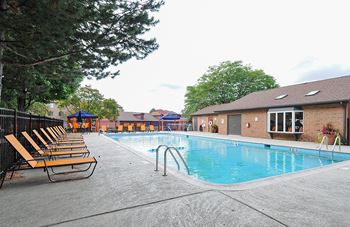 A pool with chairs around it.