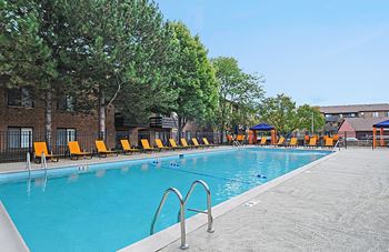 our apartments have a large swimming pool with yellow chairs