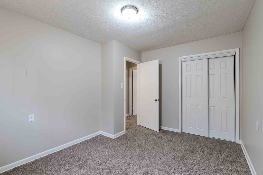 a bedroom with a white door and carpeted floor at Fay Street Apartments, Virginia, 22601