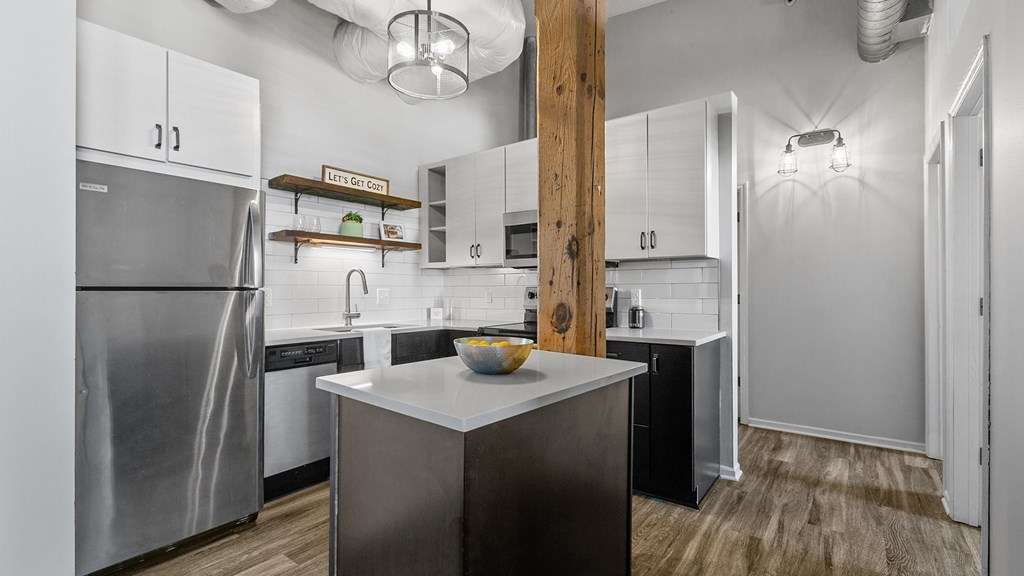 A modern kitchen with a wooden pillar in the middle.
