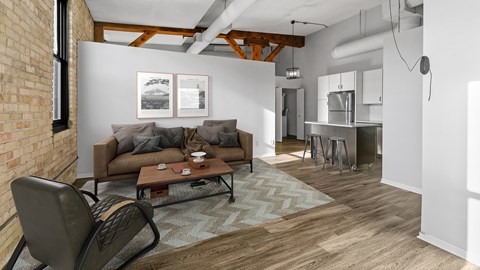 A living room with a brown couch and a chair.