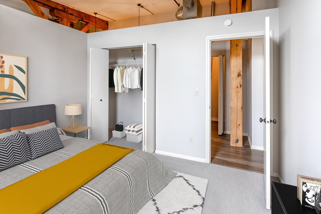 A bedroom with a bed, a lamp, a rug and a painting on the wall.