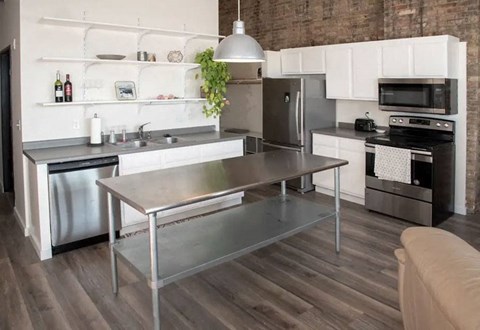 a kitchen with a stainless steel table and stainless steel appliances  at Gaar Scott Historic Lofts, Minneapolis, MN, 55401