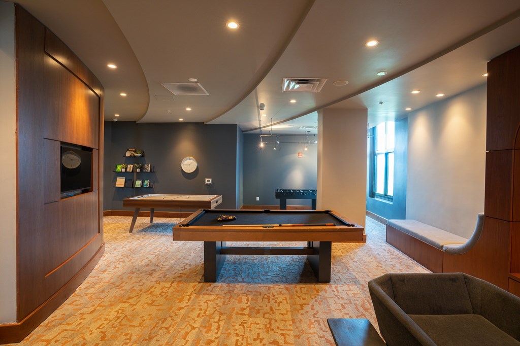 A room with a pool table and a couch.