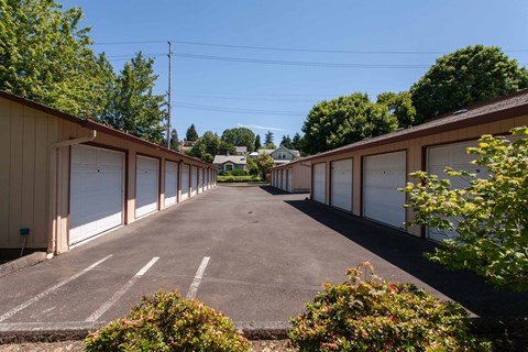 A parking lot with a row of garages on either side at Julie Ann, Portland
