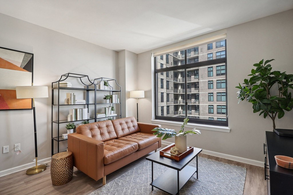 a living room with a brown couch and a large window