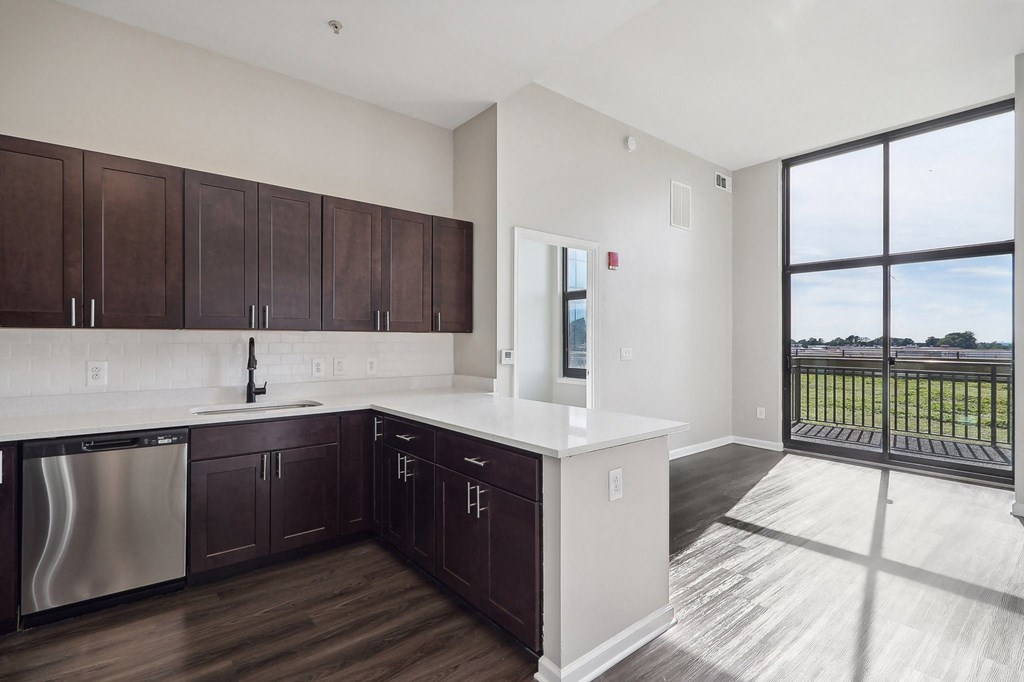 Kitchen with dark brown cabinets, stainless steel appliances and large window