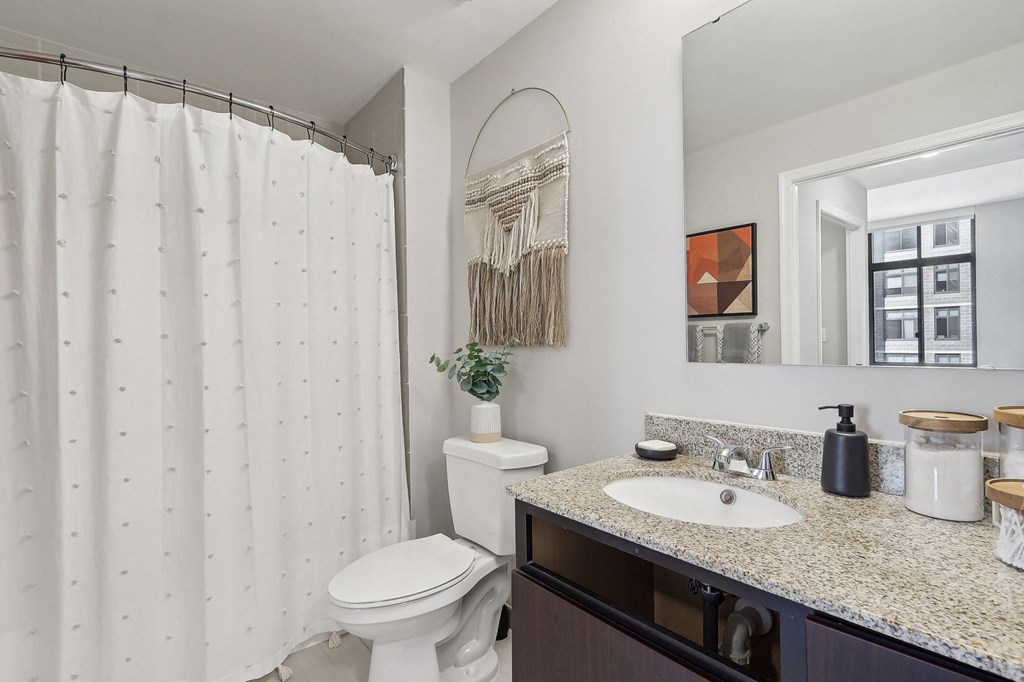 a bathroom with a shower and a sink and a toilet