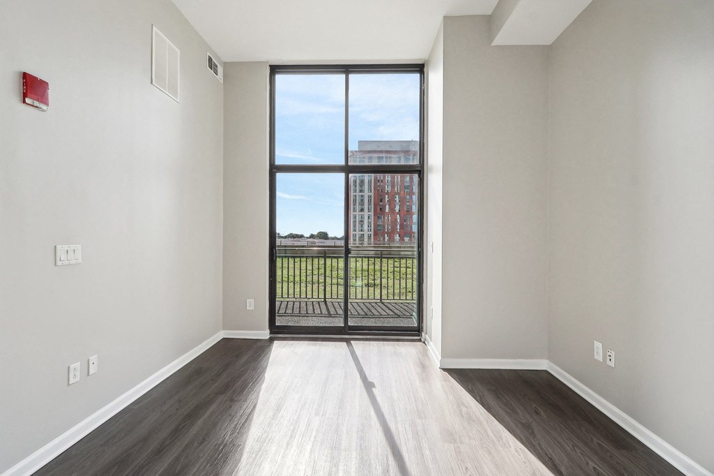 an empty living room with a door to a balcony