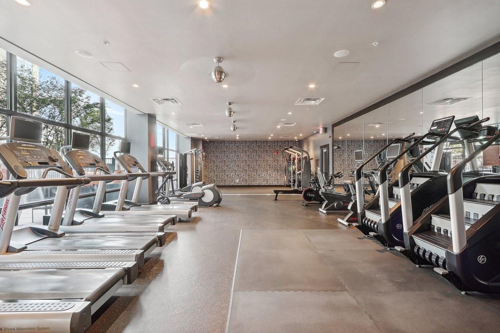 fitness center with cardio equipment and large windows