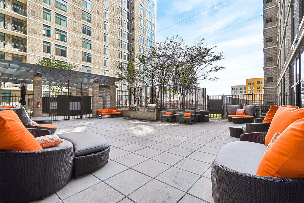 an outdoor patio with chairs and tables and a building in the background
