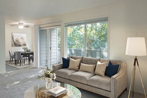 A living room with a grey couch, a coffee table, and a painting on the wall.