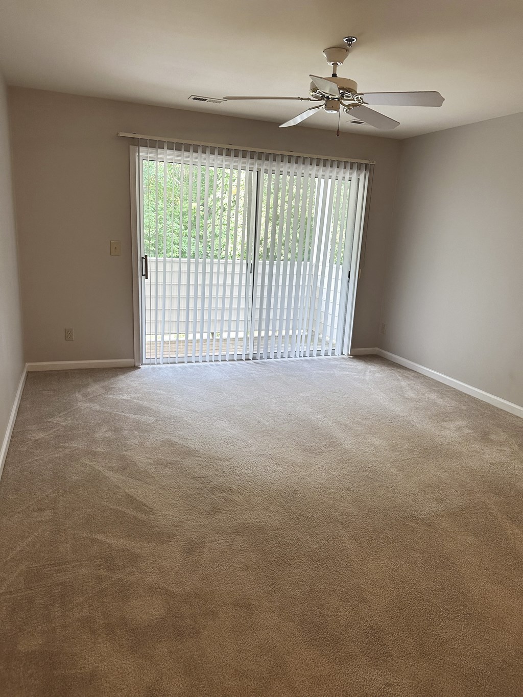 an empty room with a sliding glass door and a ceiling fan at Woodgate, Charlottesville, Virginia