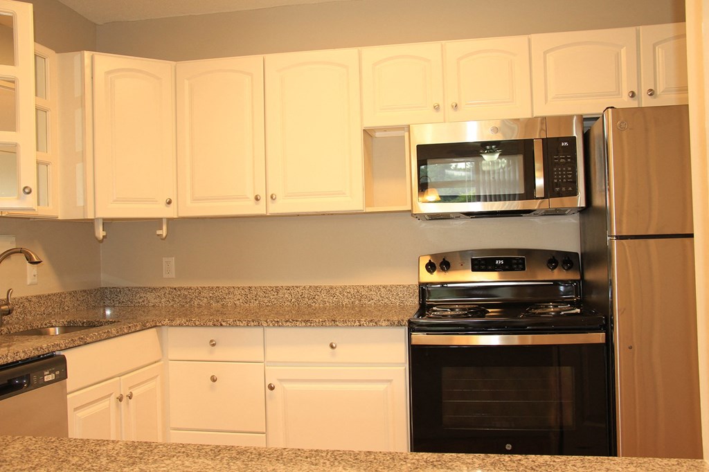 a kitchen with white cabinets and a stove and a microwaveat Renew Worcester, Worcester, MA, 01602