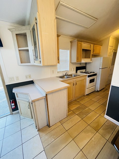 A kitchen with wooden cabinets and a white counter.