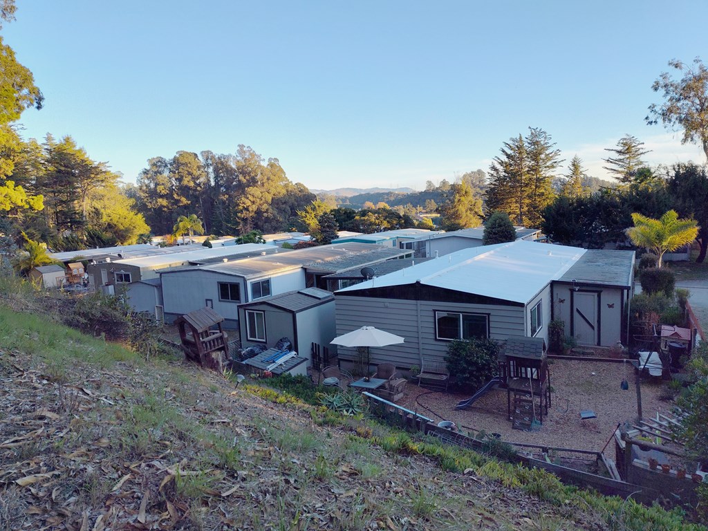 A group of houses are surrounded by trees and grass at Salinas Sunset Apartments, Salinas, CA, 93907