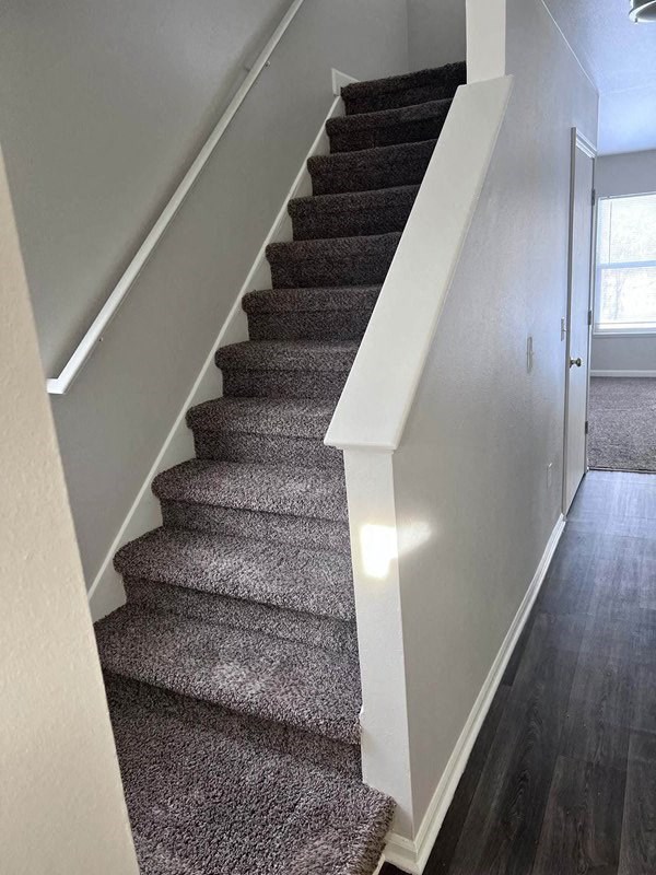 a carpeted staircase in a home with white walls at Mason Street Townhomes, Grand Rapids, 49505