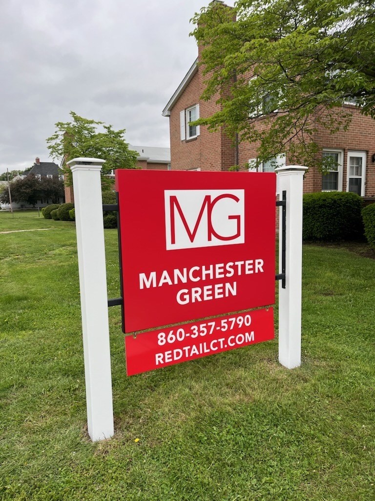 A sign for Manchester Green with a phone number and website.
