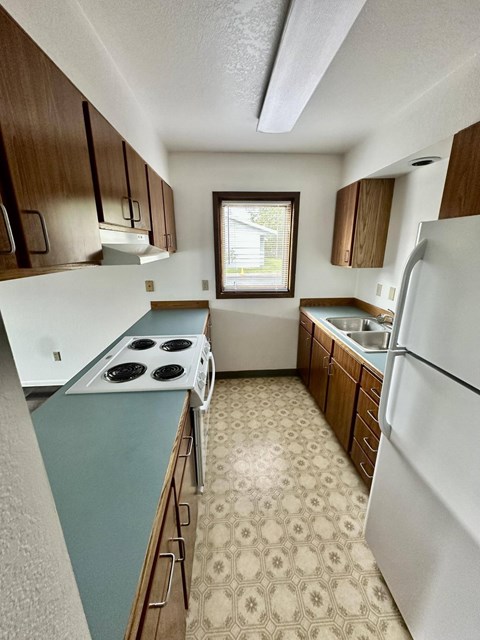A kitchen with a white fridge and a white stove top.