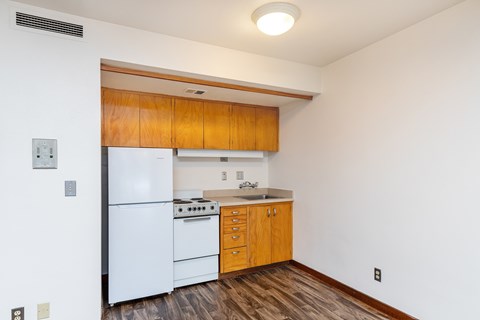 A kitchen with wooden cabinets and a white refrigerator.