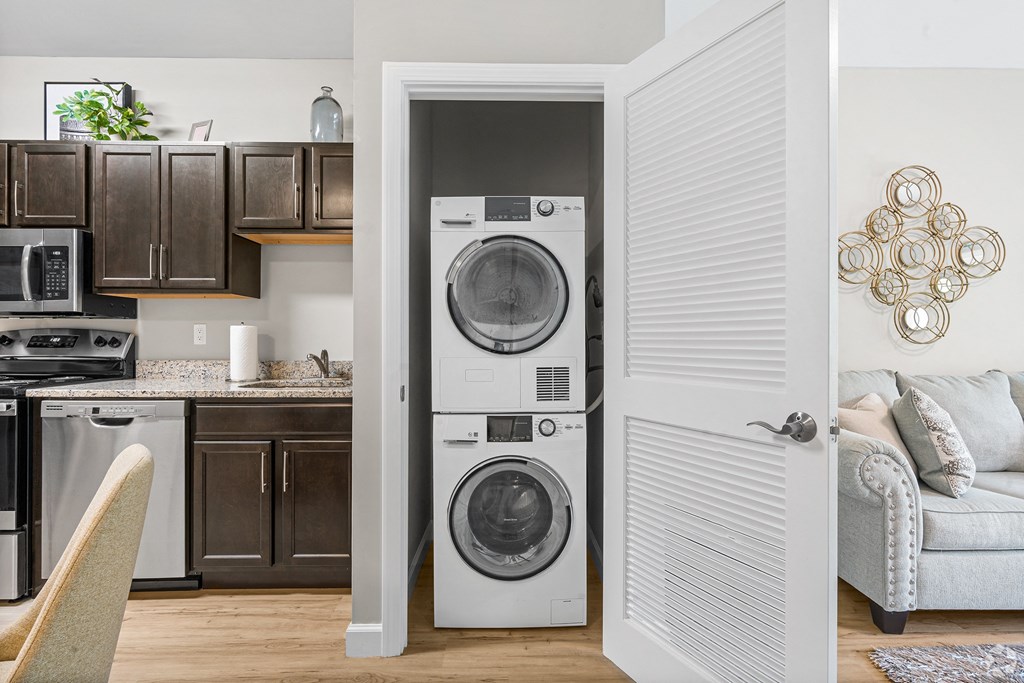 a living room and kitchen with a washing machine and a washer and dryer in it at Lofts at 335, Stratford, 06615