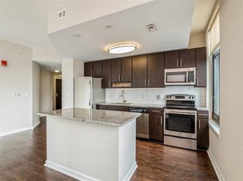A kitchen with a granite countertop and stainless steel appliances.