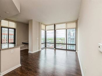 A large empty room with a view of the city through the windows.